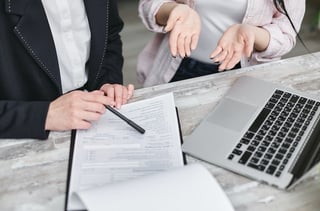 person holding pen signing paper